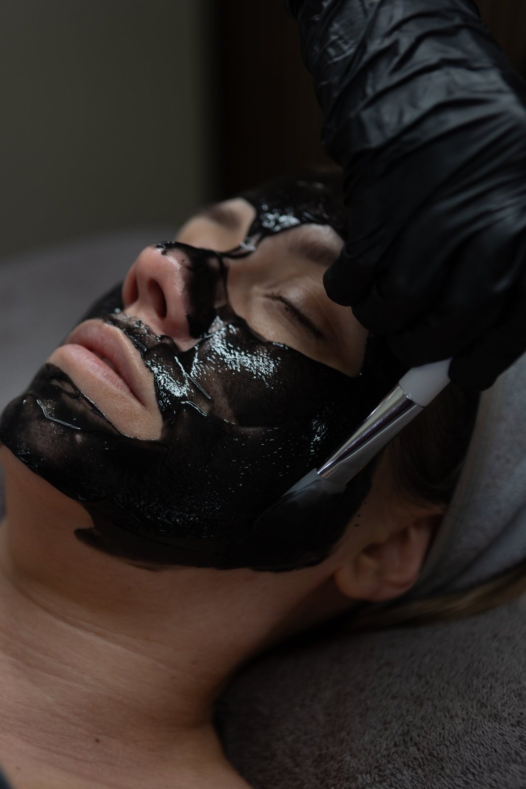 Charcoal mask being applied with a brush