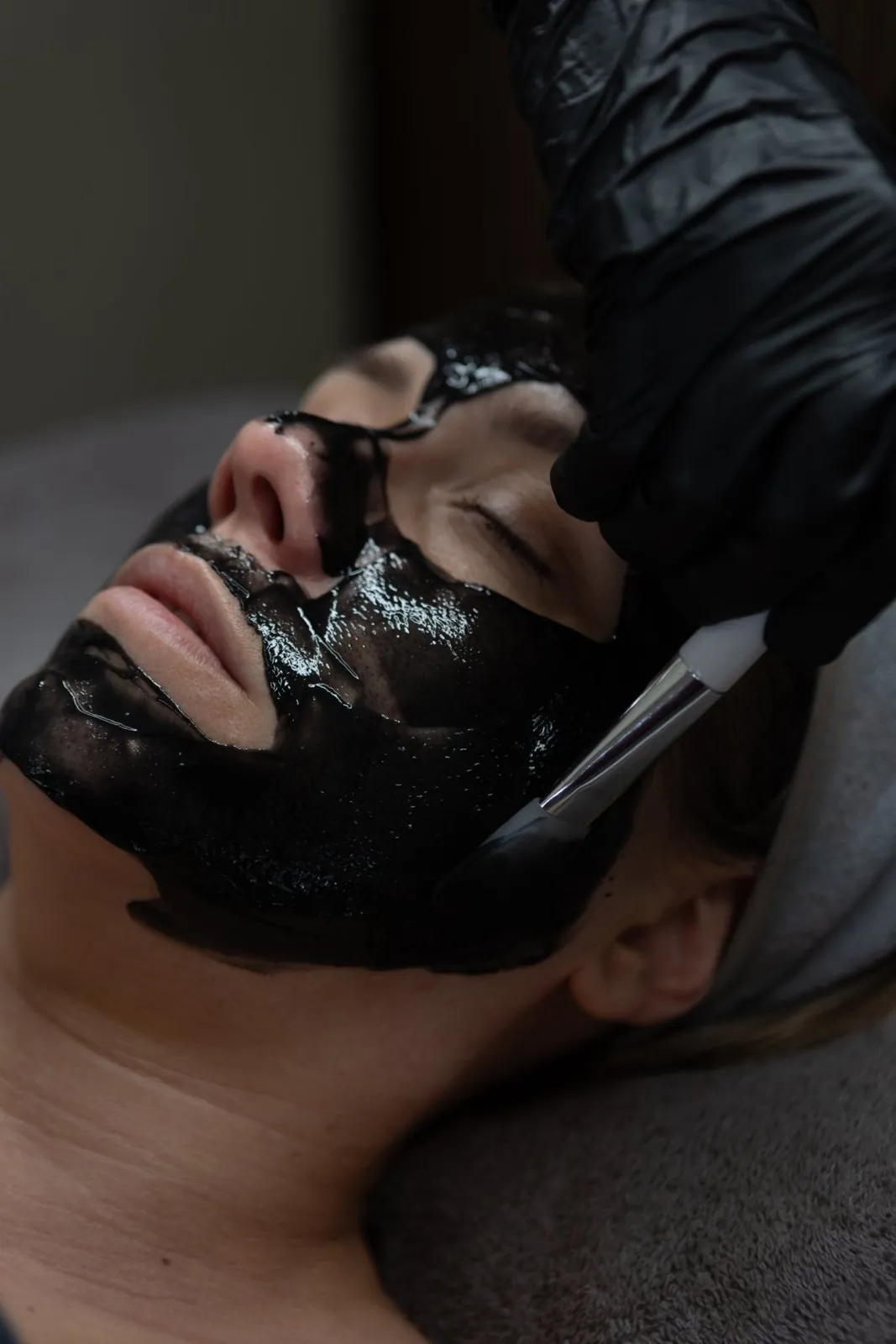 Charcoal mask being applied with a brush